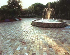 Tan and white circular driveway with fountain in the center