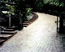 Descending paver driveway with paver stairs adjacent 