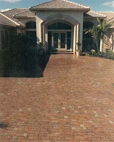 Huge driveway and entranceway made of brown pavers in a circular pattern