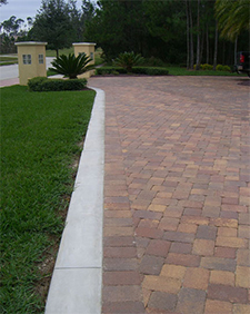 Red paver driveway edged with white concrete