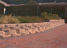 Red paver walkway with low wall