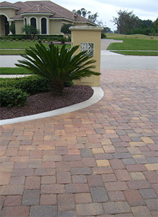 Assorted color paver driveway edged with concrete